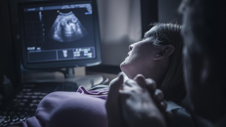 A mother listening to baby heartbeat.